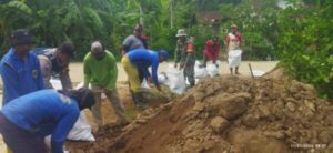 Antisipasi Banjir, Bhabinkamtibmas Desa Angkatan Lor Bersama Warga Kerja Bakti Pembuatan Tanggul Sungai