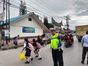 Dengan Semangat, Polres Humbahas Bantu Anak-Anak Sekolah Menyebrang Jalan